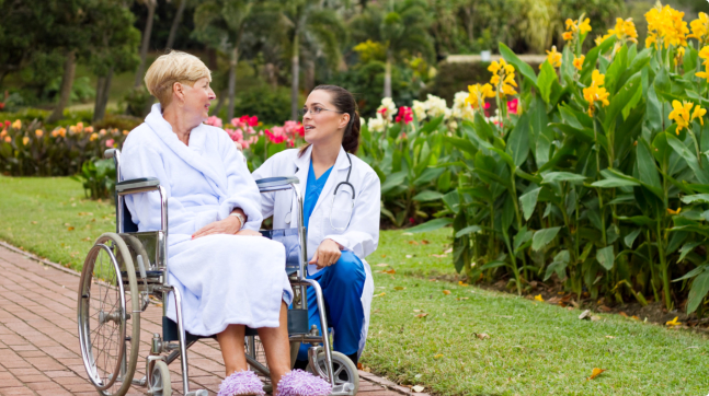 caregiver talking to the elder woman outdoors