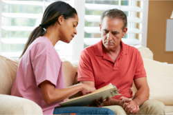 caregiver presenting a document to the elder man